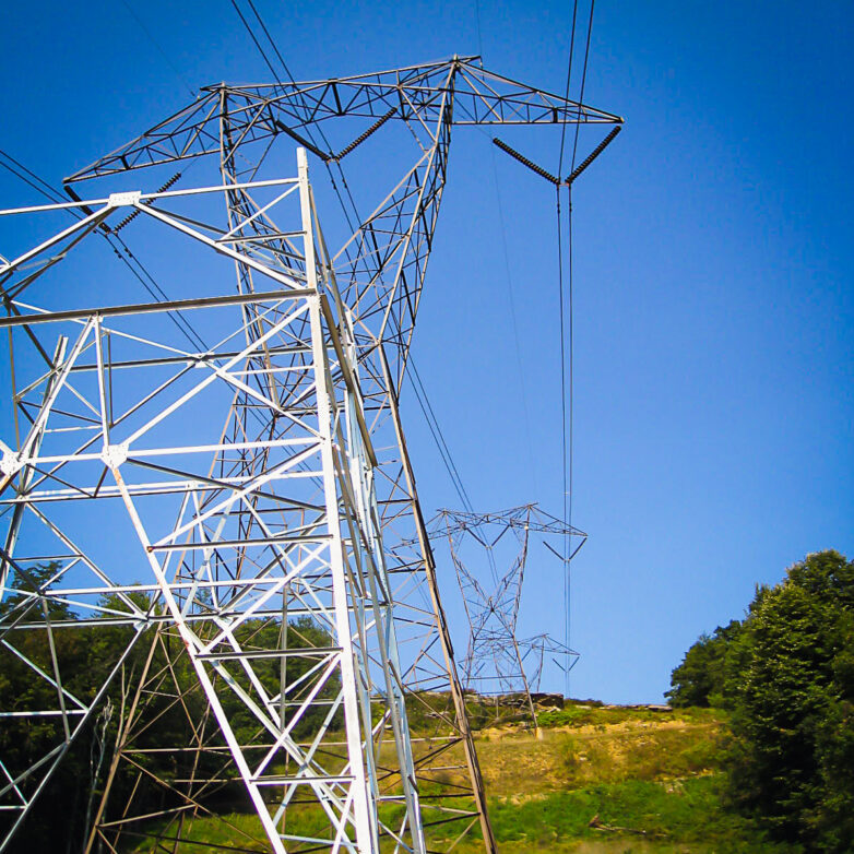 Transmission towers on a grassy hill