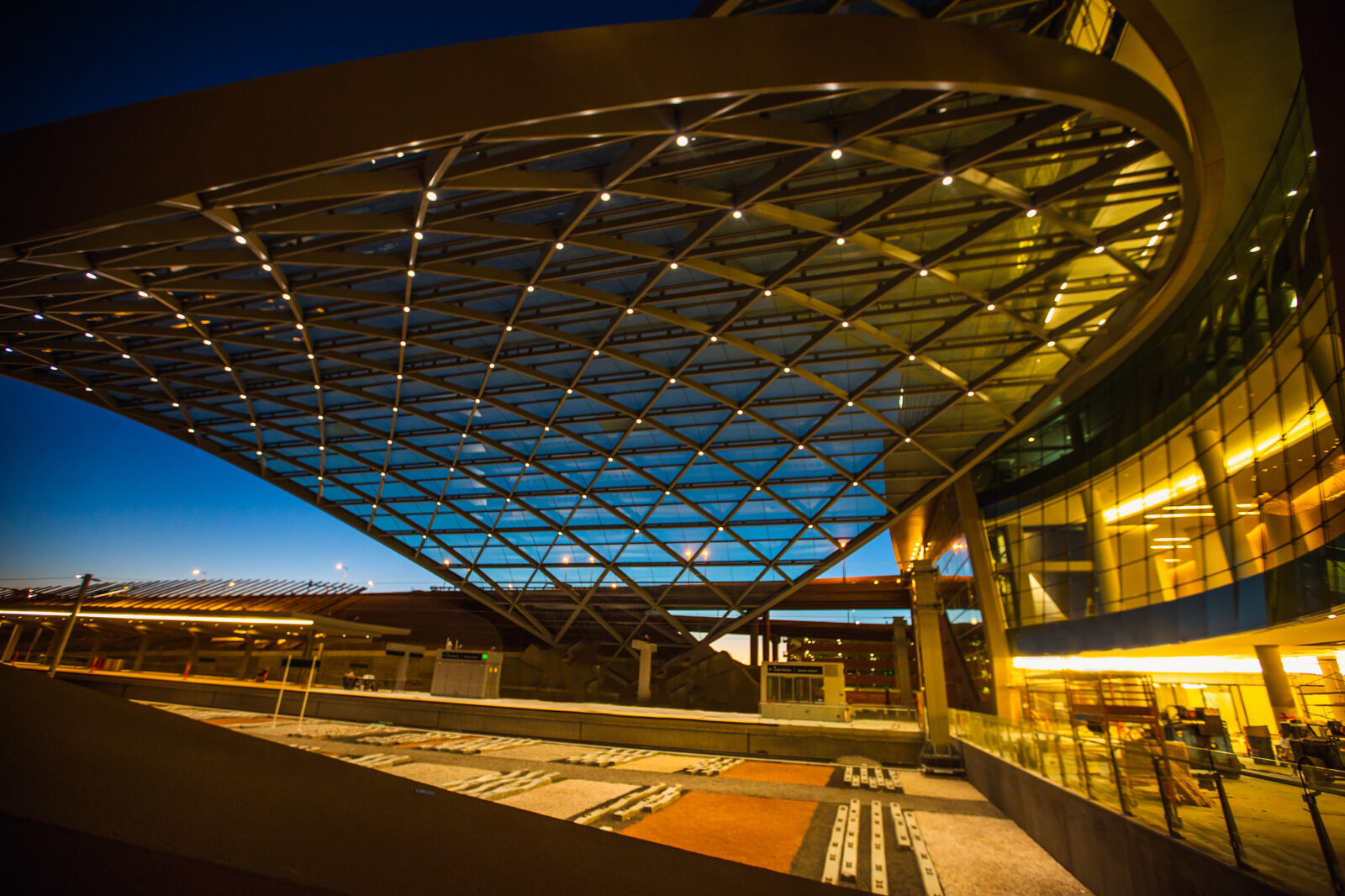 Lit up structural design outside of the Denver International Airports main terminal at night