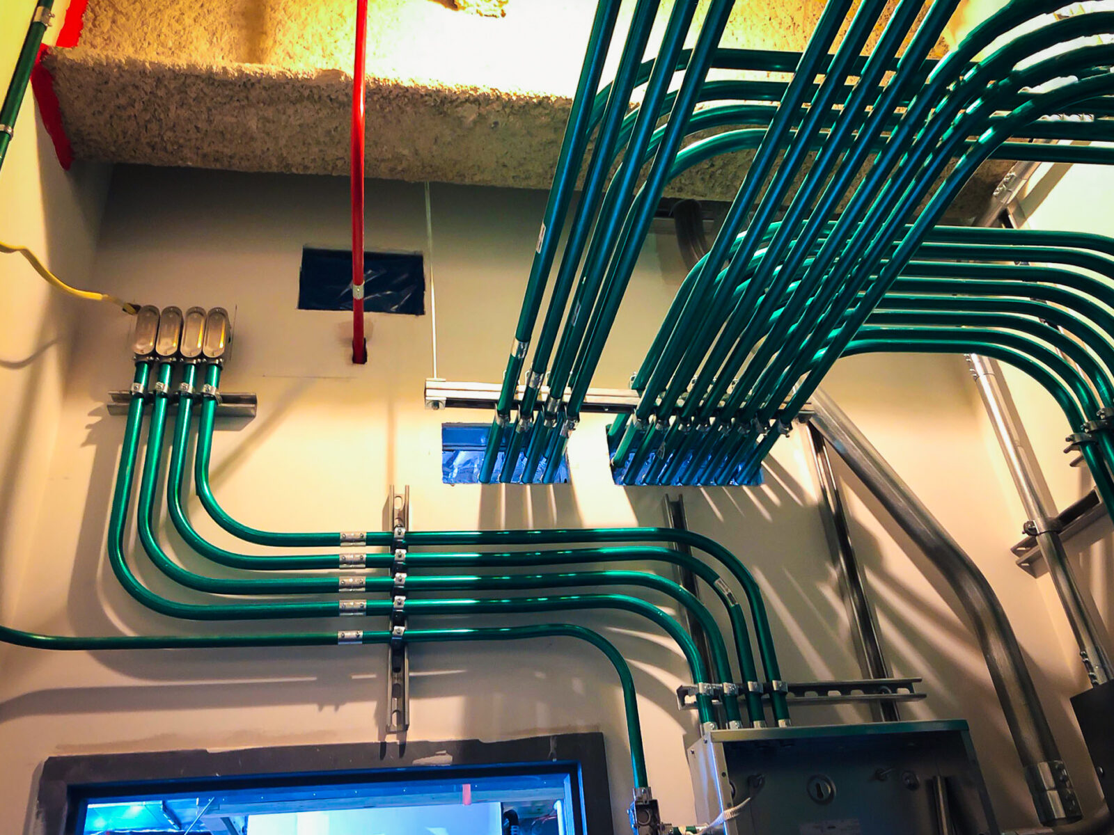 Green electrical conduit mounted to the wall