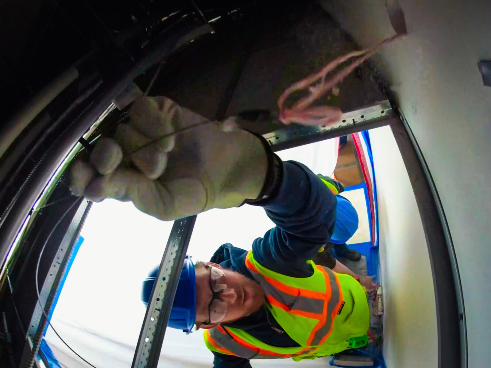 Construction worker adjusting ceiling cables
