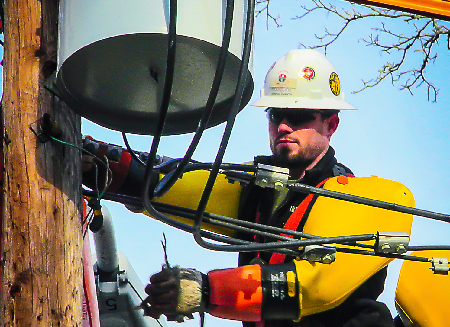 Restoration worker adjusting cables on a power line