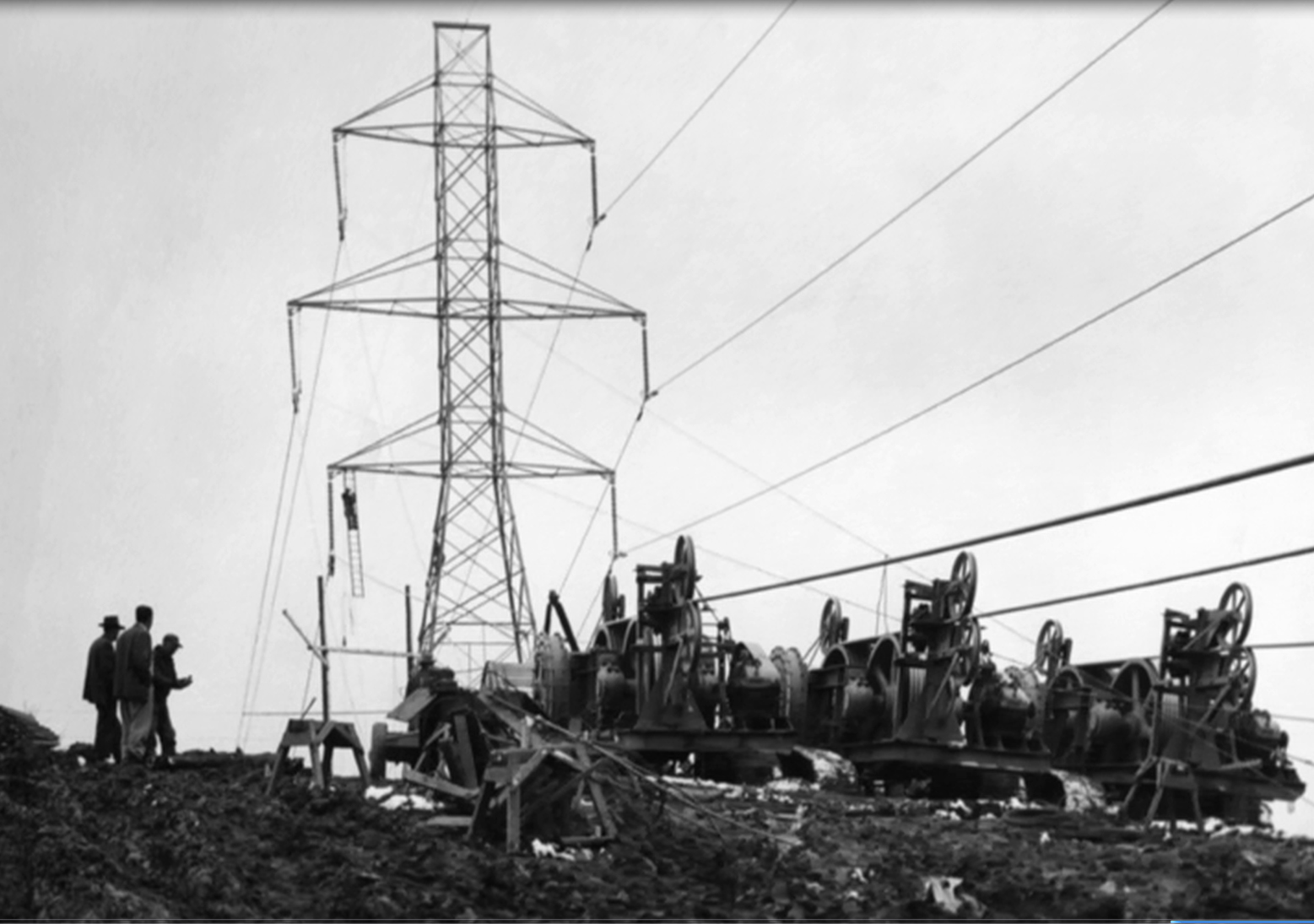 Group of workers assembling the wires of a transmission tower