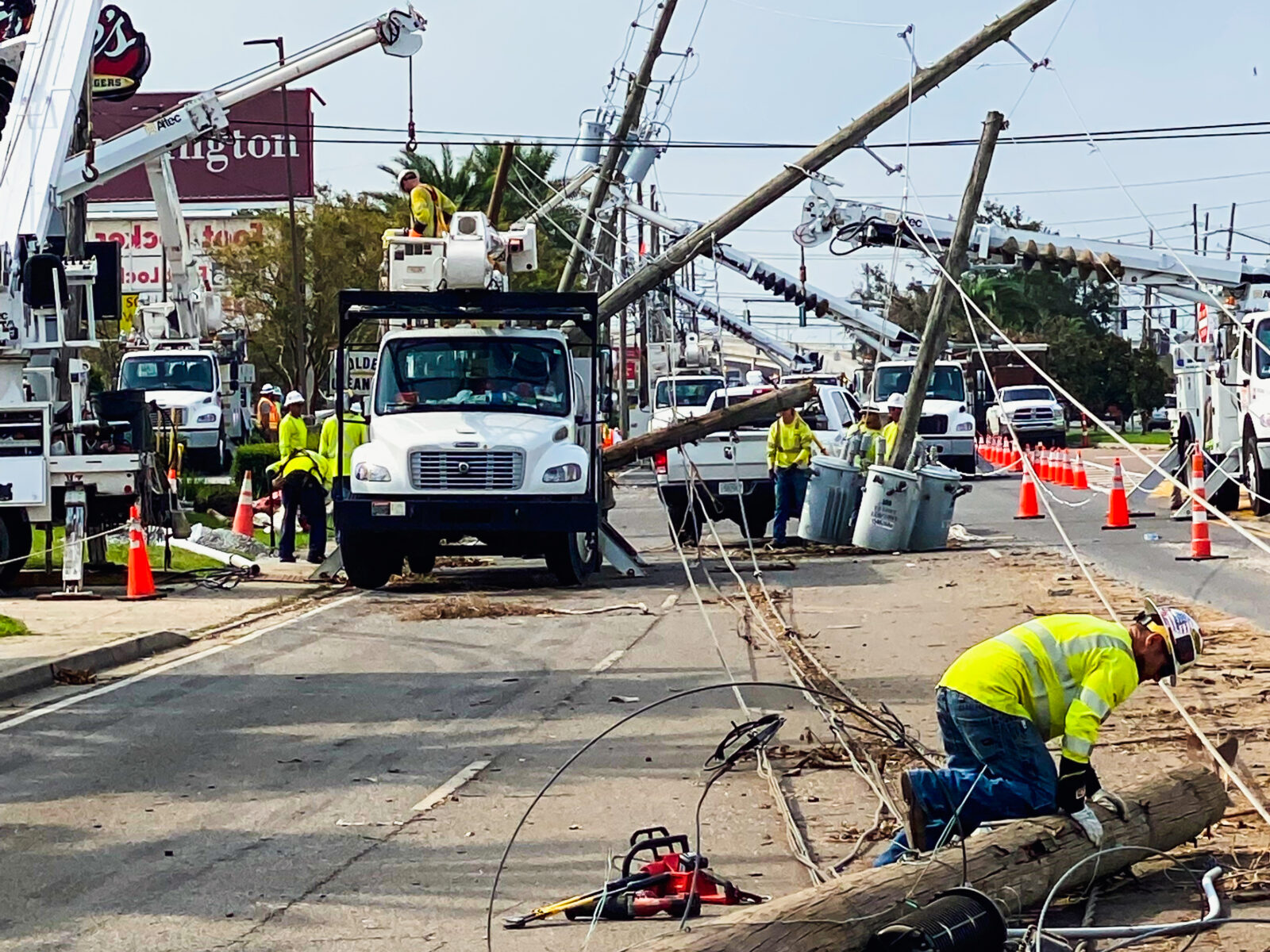 Restoration workers removing debris from damaged power lines on the road