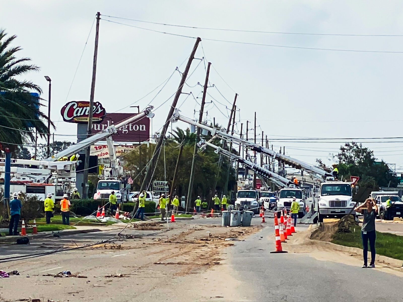 Restoration workers fixing power lines with debris on the road