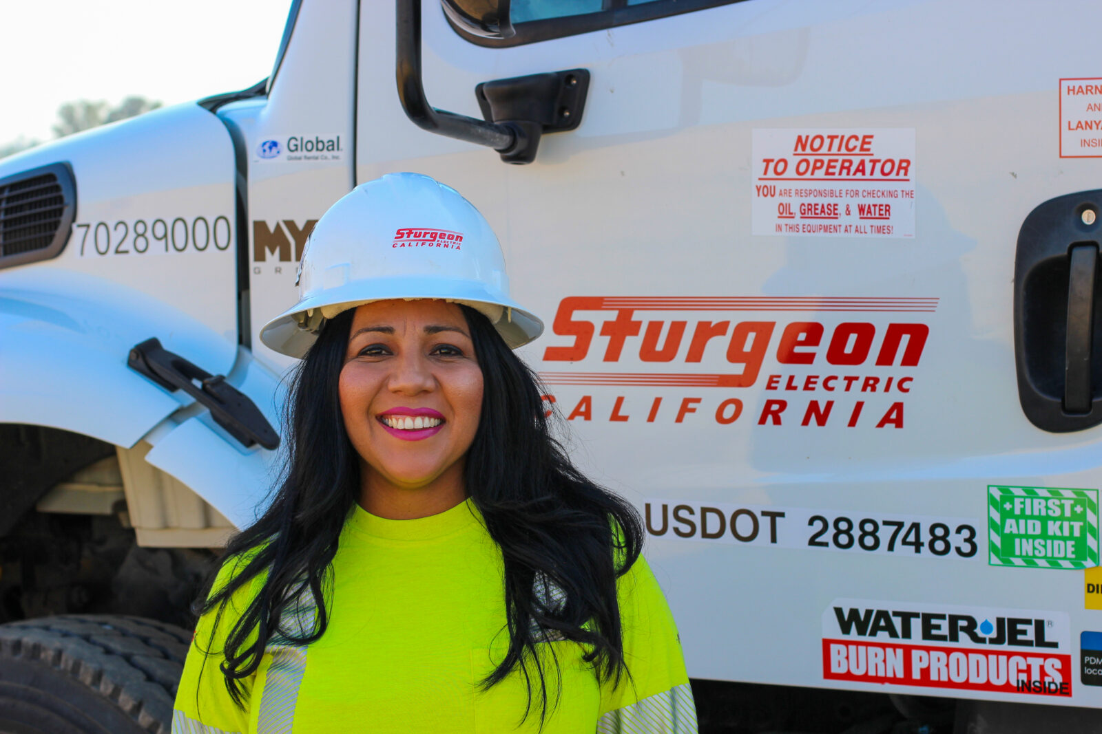 Jessica Pelayo poses for a photo in front of a Sturgeon Electric truck